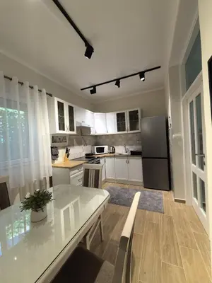 a kitchen with a table and a refrigerator at Sunny Hill - Parking - Fenced Garden - Luxury Loft in Kotor