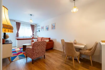 a living room with a couch and a table and chairs at Geppetto Apartment in Podgorica