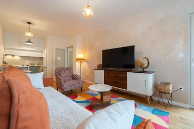a living room with a couch and a flat screen tv at Geppetto Apartment in Podgorica