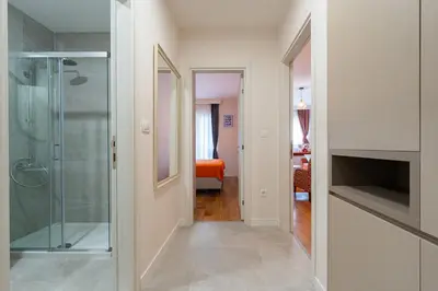 a hallway with a glass shower in a room at Geppetto Apartment in Podgorica