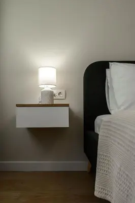 a bed with a table with a lamp on it at Lux Apartment 88 in Kotor