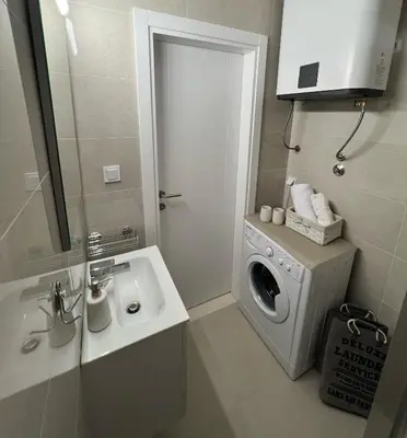 a bathroom with a washing machine and a sink at Lux Apartment 88 in Kotor