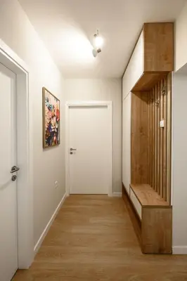 a hallway with a white door and a wooden stair case at Lux Apartment 88 in Kotor