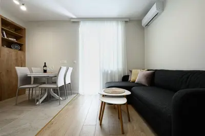 a living room with a black couch and a table at Lux Apartment 88 in Kotor