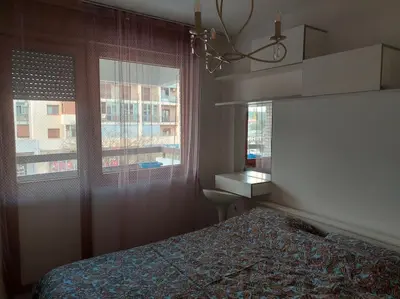a bedroom with a bed and a window at Modern 1-bedroom condo with free parking & fast WiFi in Podgorica