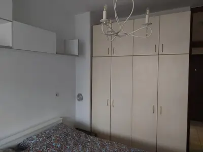 a bedroom with white cabinets and a chandelier at Modern 1-bedroom condo with free parking & fast WiFi in Podgorica