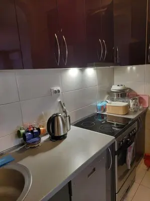 a kitchen with a sink and a stove top oven at Modern 1-bedroom condo with free parking & fast WiFi in Podgorica
