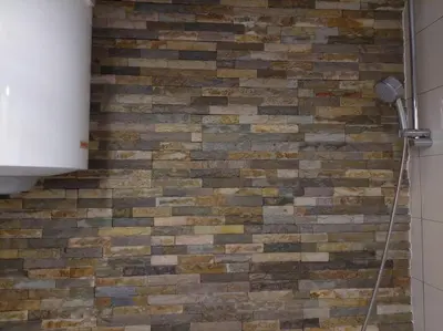 a brick wall with a shower in a bathroom at Modern 1-bedroom condo with free parking & fast WiFi in Podgorica