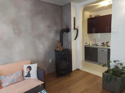 a living room with a couch and a wood stove at Modern 1-bedroom condo with free parking & fast WiFi in Podgorica