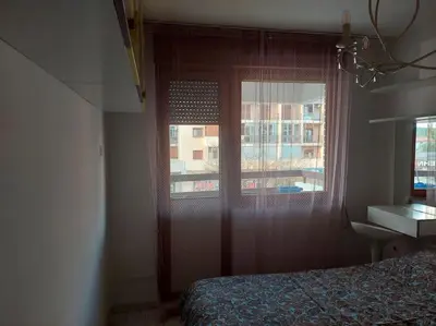 a bedroom with a window and a bed and a desk at Modern 1-bedroom condo with free parking & fast WiFi in Podgorica