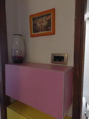 a purple shelf with a vase and a clock on it at Modern 1-bedroom condo with free parking & fast WiFi in Podgorica