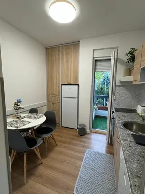 a kitchen with a sink and a table with chairs at Eleven in Podgorica