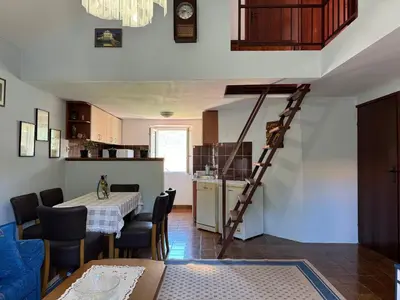 a kitchen and a dining room with a spiral staircase at Santa Maria - Old Town Apartment in Budva
