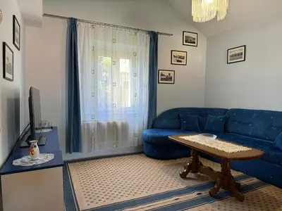 a living room with a blue couch and a table at Santa Maria - Old Town Apartment in Budva