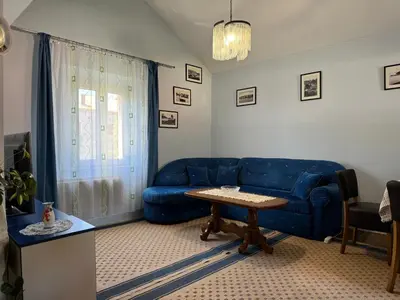 a living room with a blue couch and a table at Santa Maria - Old Town Apartment in Budva