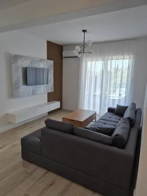a living room with a black couch and a table at Frekuenca Apartments in Ulcinj