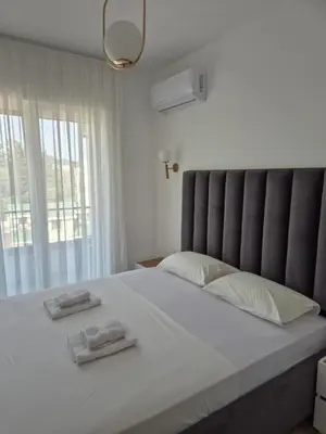 a bedroom with a large bed with two towels on it at Frekuenca Apartments in Ulcinj