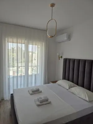 a bedroom with a large bed with two towels on it at Frekuenca Apartments in Ulcinj