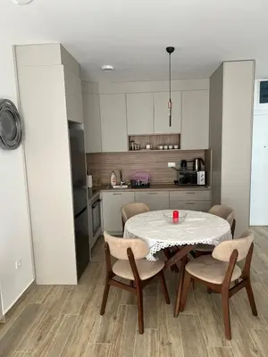 a kitchen with a table and chairs in a kitchen at Apartment Veljko Becici in Becici