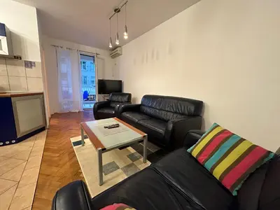 a living room with black leather furniture and a table at Aprtment Mili in Budva