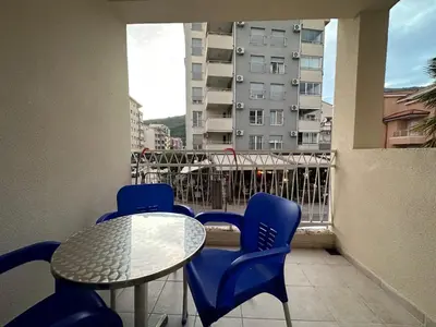 a table and chairs on a balcony with a building at Aprtment Mili in Budva