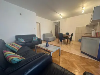 a living room with a black leather couch and a tv at Aprtment Mili in Budva
