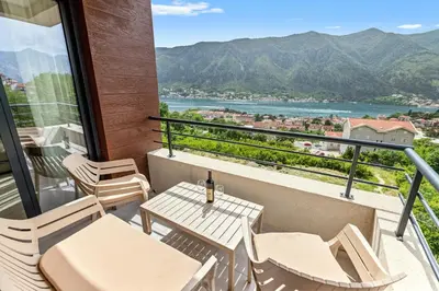 a balcony with a table and chairs and a view at ALISA Sea View Apartment in Kotor