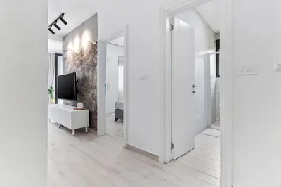 a hallway with white walls and a tv and a door at ALISA Sea View Apartment in Kotor