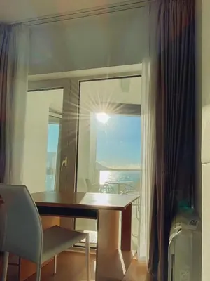 a table and a chair in a room with a window at Apartment in Tre Canne in Budva