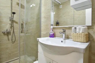 a bathroom with a sink and a shower at Dolami residence in Becici