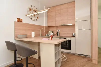 a kitchen with a counter with two chairs and a island at Dolami residence in Becici