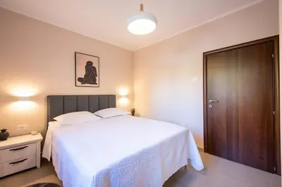 a bedroom with a white bed and a wooden door at Bubi in Kotor