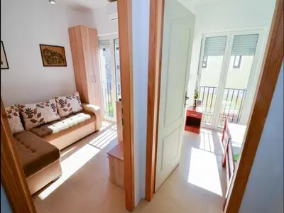 a living room with a couch and a balcony at Apartment Anlave in Sveti Stefan