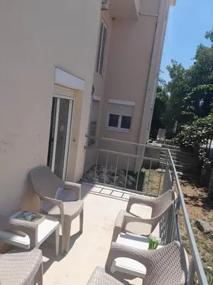 a group of chairs and tables on a balcony at Apartment Anlave in Sveti Stefan