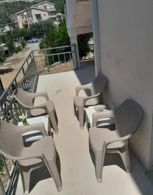 a row of chairs and tables on a balcony at Apartment Anlave in Sveti Stefan