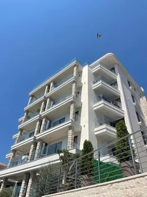 a large white apartment building with stairs in front of it at DH Horizon Residences in Budva