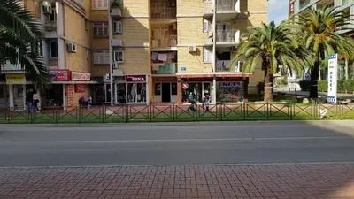 an empty street in front of a building with palm trees at Apartments Moreno in Budva