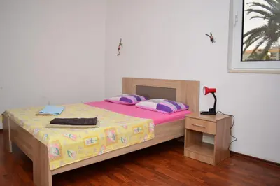 a bedroom with a bed and a lamp on a table at Apartments Moreno in Budva