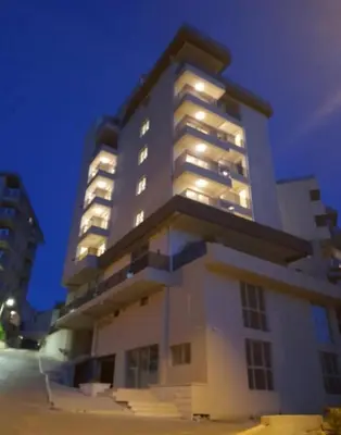 a large white building with lights on it at Apartment Becici in Becici