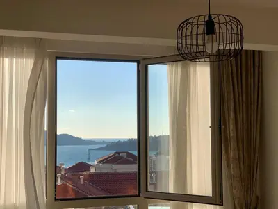 a room with a window with a view of the ocean at Apartment Becici in Becici