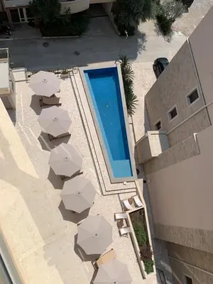 an overhead view of a swimming pool with chairs and umbrellas at Apartment Becici in Becici