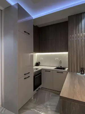 a kitchen with white cabinets and a blue light at Masha Apartment in Budva