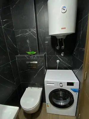 a small bathroom with a washing machine and a toilet at Masha Apartment in Budva
