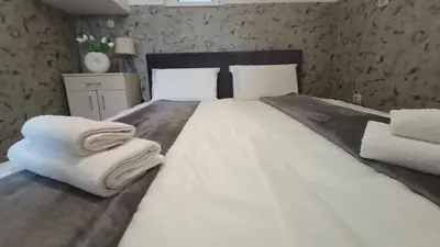 a bedroom with a large white bed with towels on it at Apartment deluxe Ina FREE PARKING in Budva