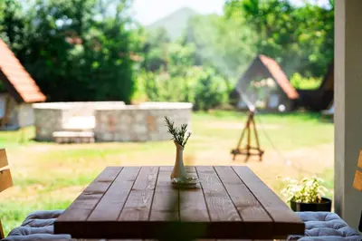 a wooden table with a vase with a plant on it at NAJ village in Cetinje