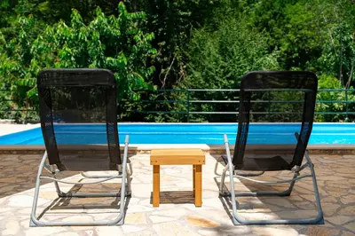 two chairs and a table in front of a pool at NAJ village in Cetinje