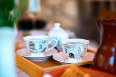 two tea cups and saucers on a wooden table at NAJ village in Cetinje