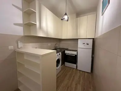 a kitchen with white cabinets and a washer and dryer at Jovana Apartments 2 in Budva