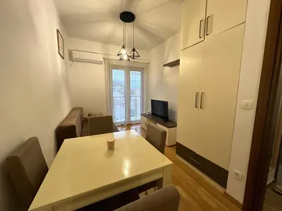 a living room with a table and chairs and a television at Jovana Apartments 2 in Budva