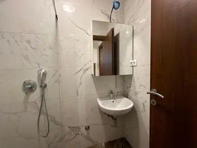 a bathroom with a sink and a shower with a mirror at Jovana Apartments 2 in Budva